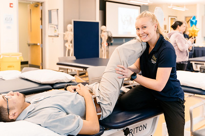 student physical therapist testing another students leg flexibility
