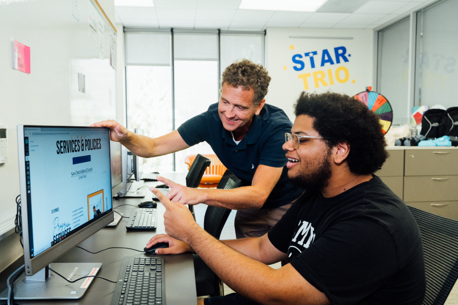 Photo: STAR TRIO counselor interacting with a student in front of a computer. 